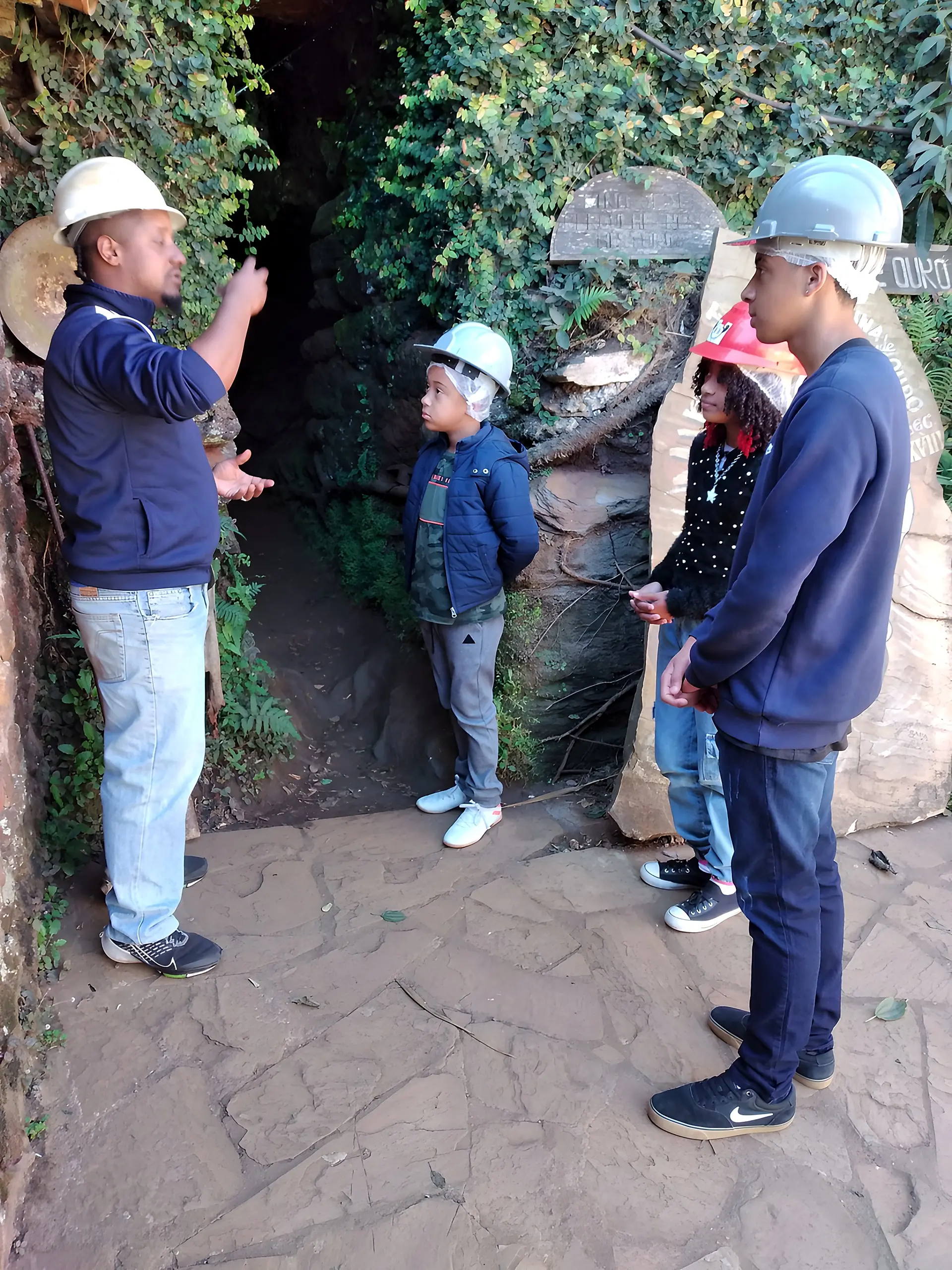 Guia conversando com visitantes na entrada da mina