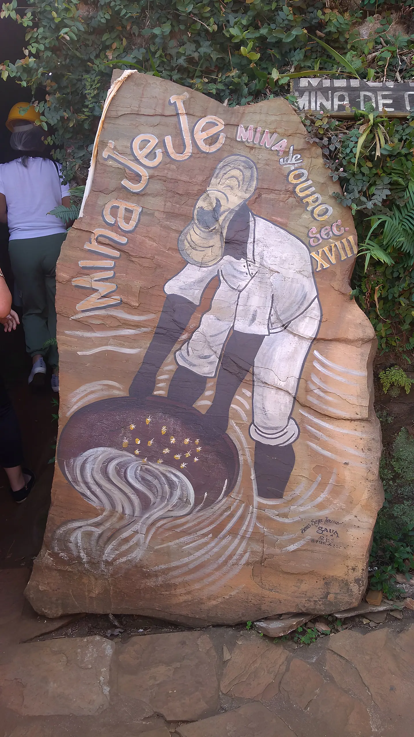 Pedra esculpida com o nome Mina Jeje e um minerador